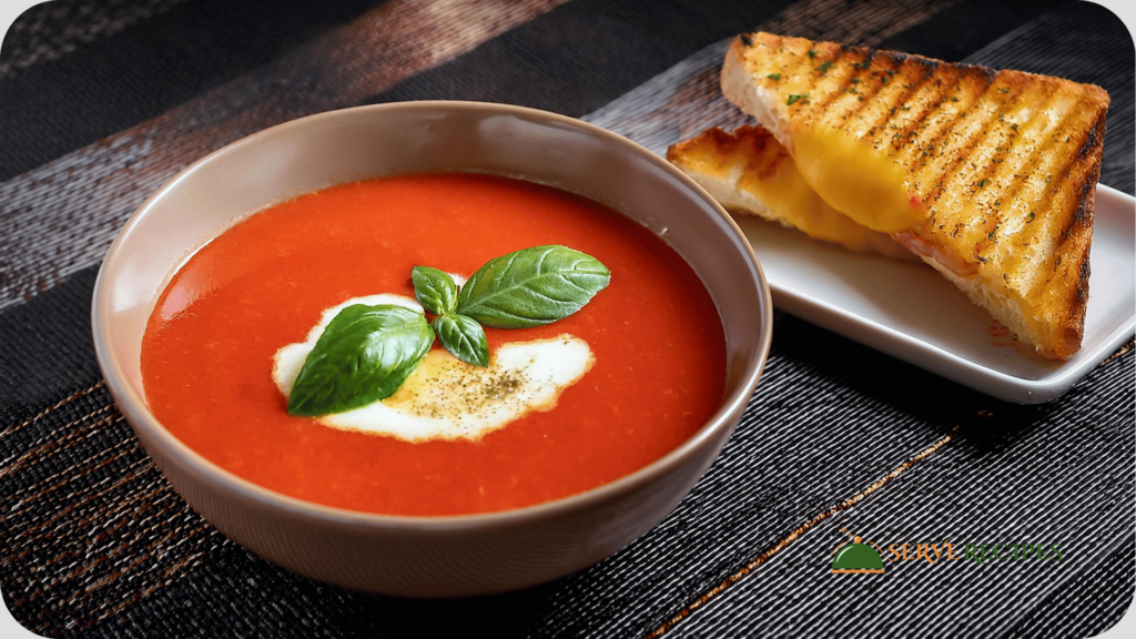 A bowl of creamy tomato basil soup served with a grilled cheese sandwich, a comforting option for quick dinner recipes.