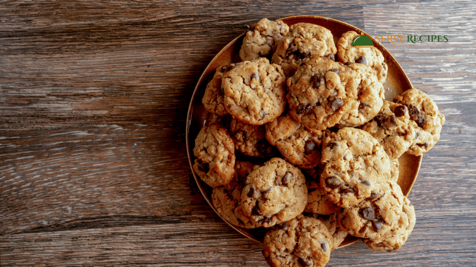 Stack of freshly baked peanut butter chocolate chip cookies on a wooden table.