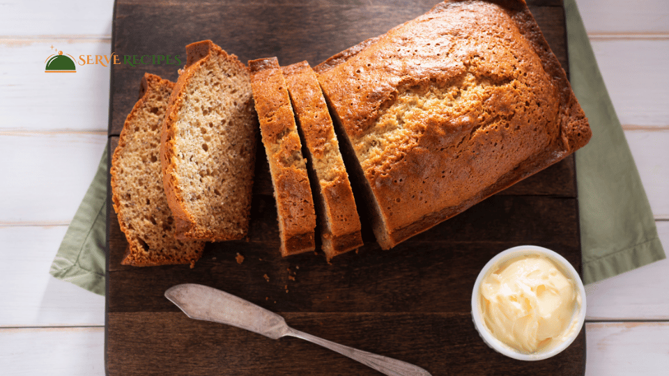 Sliced Quick banana bread on a wooden board, showcasing the moist texture and golden-brown crust.